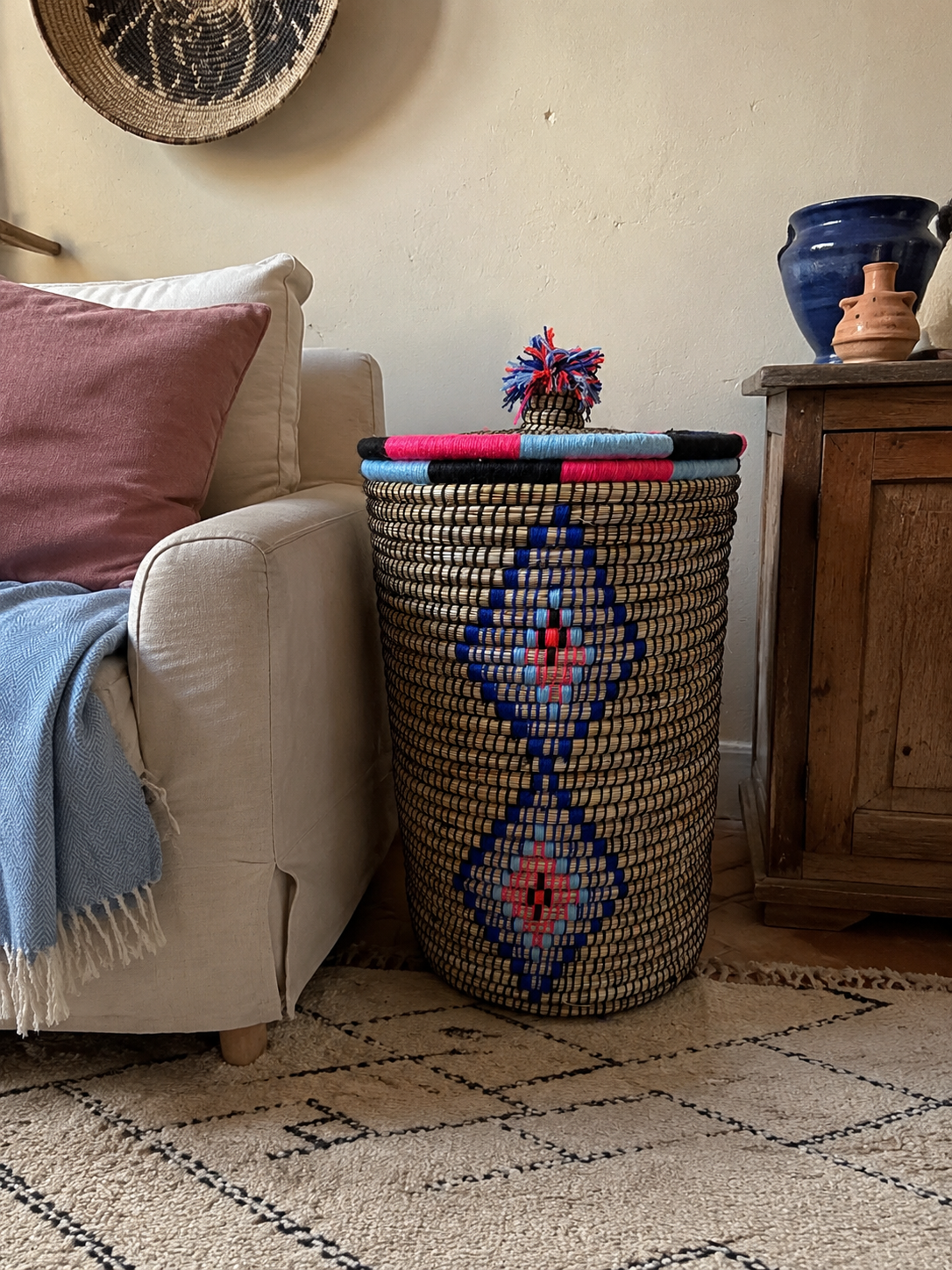 Grand panier de rangement berbère artisanal multicolore dans un salon bohème