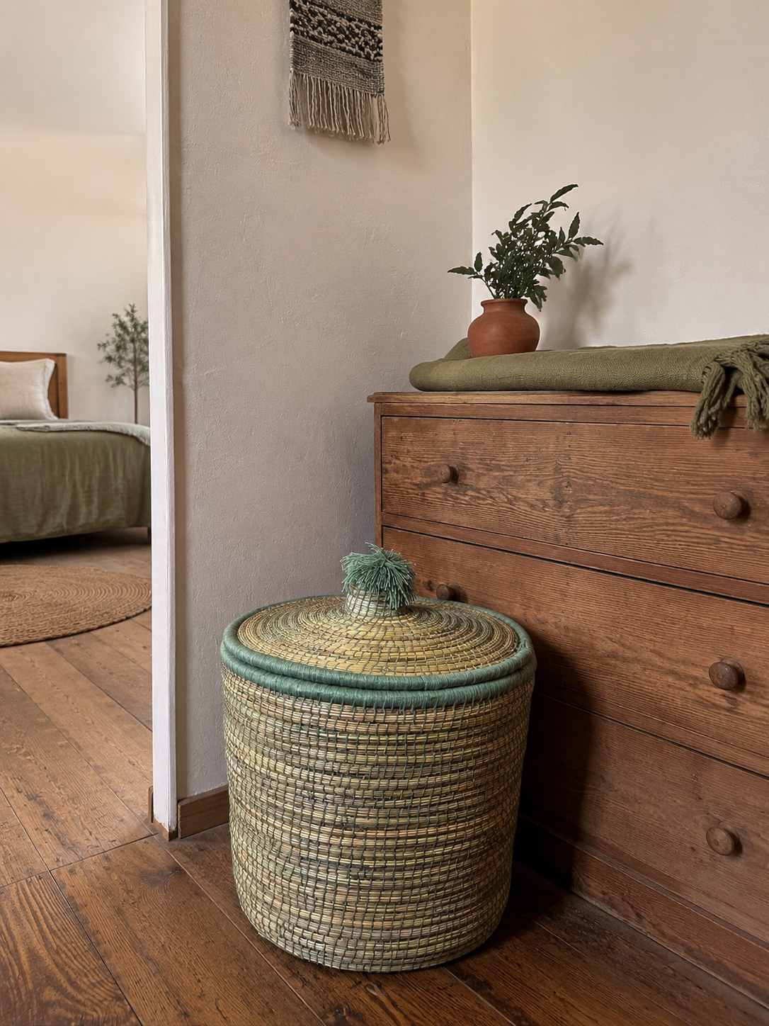 Panier de rangement berbère artisanal vert sauge dans une chambre bohème