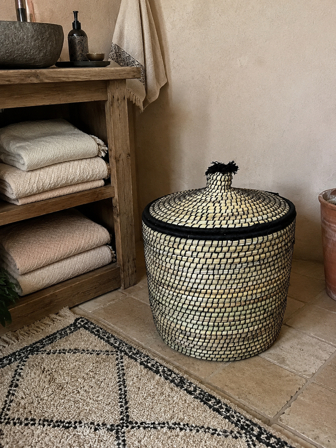 Panier de rangement berbère noir et naturel dans une salle de bain bohème