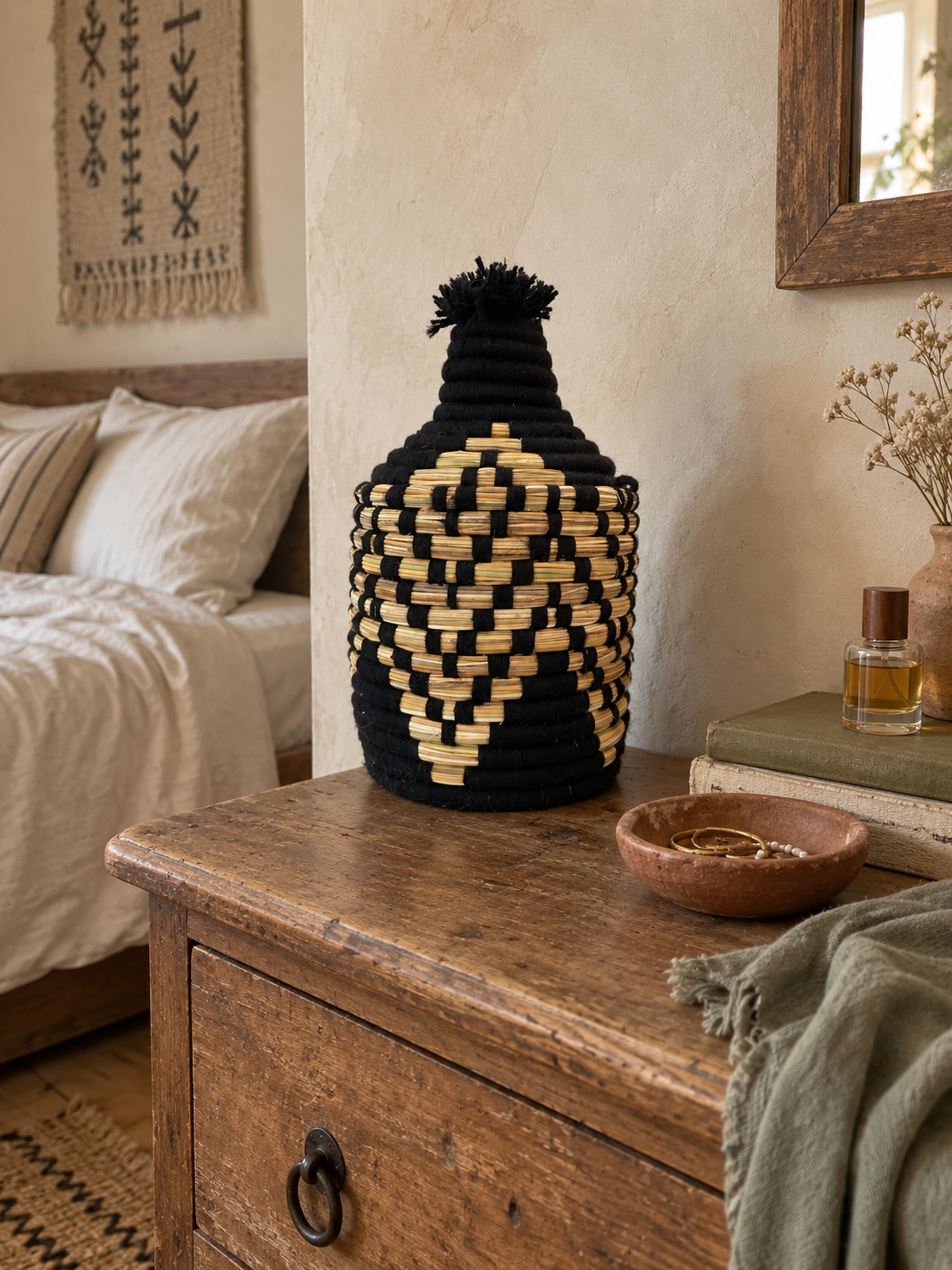 Petit panier de rangement berbère noir posé sur une commode dans une chambre bohème