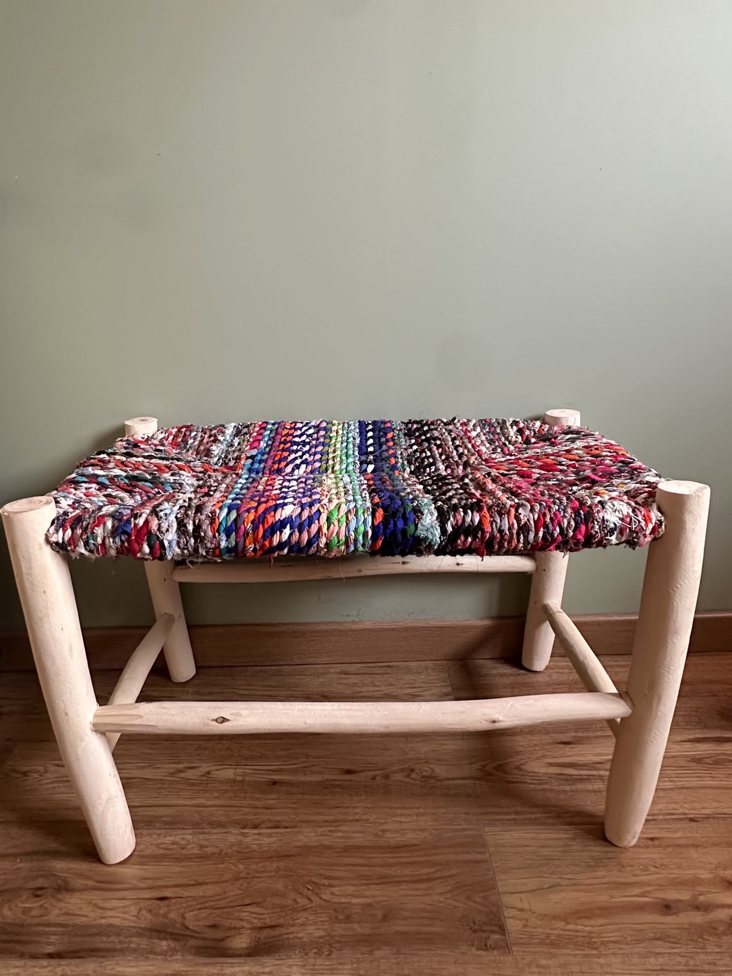 Banc artisanal en bois naturel avec assise tissée en chutes de tissu multicolores aux tons intenses, pièce unique faite main.