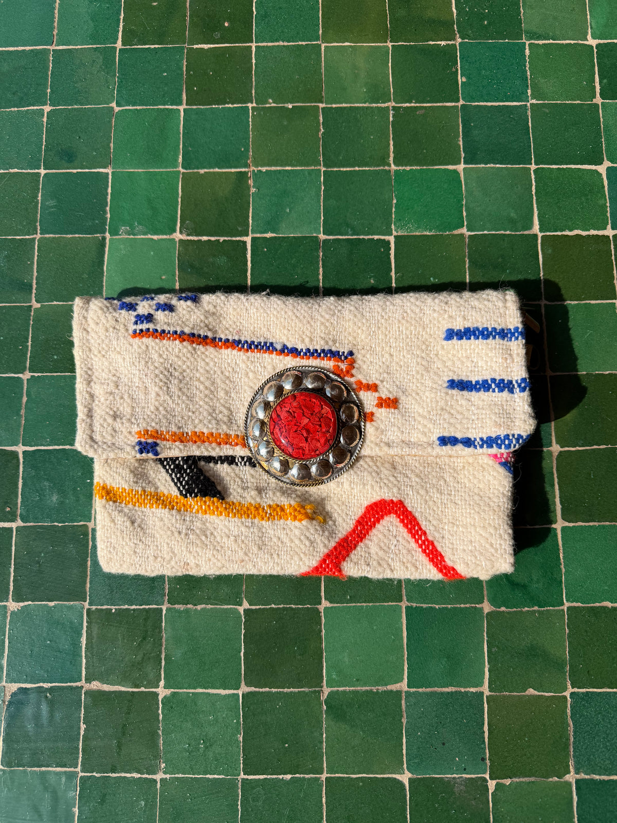 Pochette berbère écrue à motifs bleus et orange, médaillon rouge et bandoulière chaîne argentée