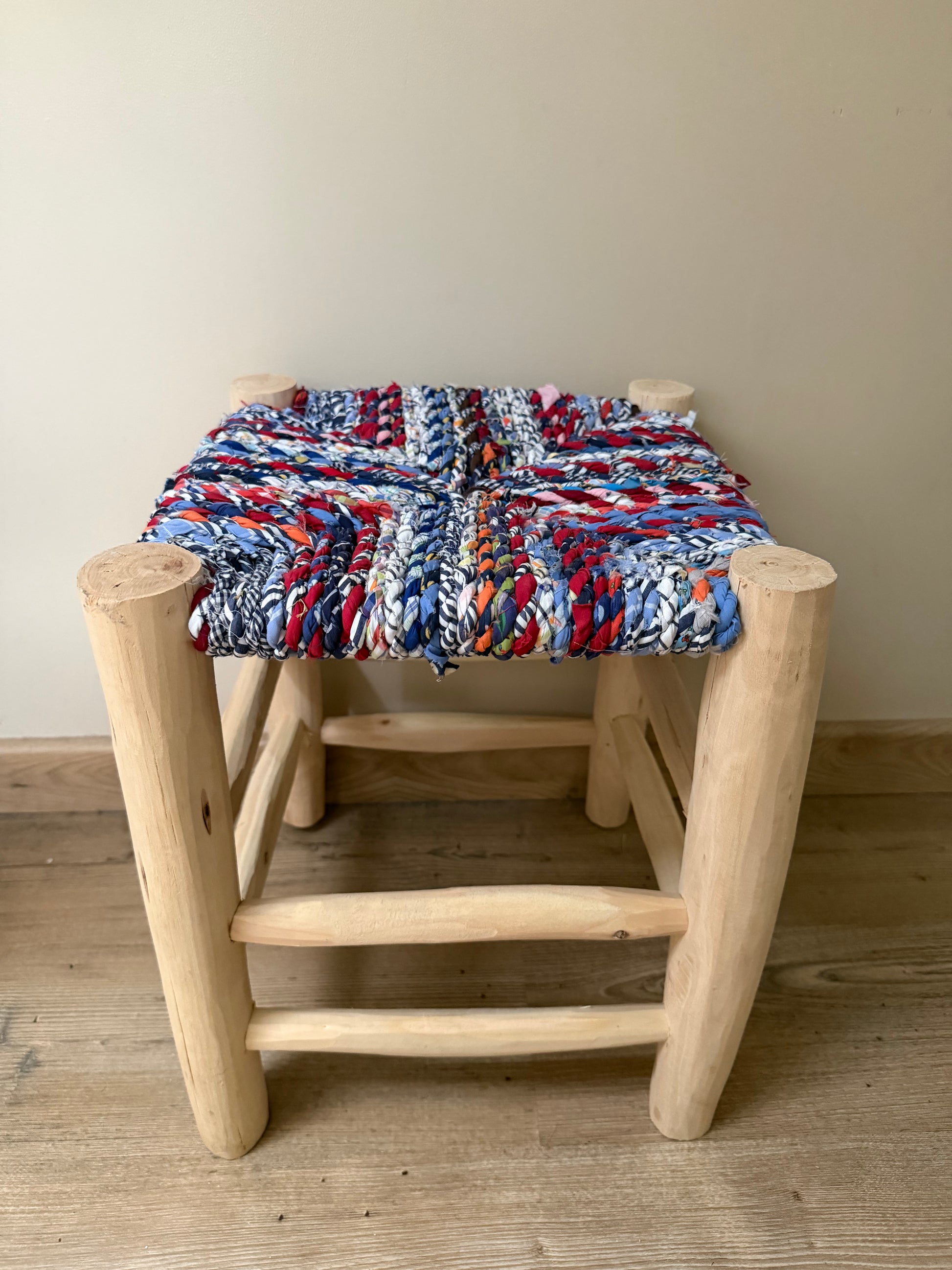 Tabouret Boucherouite artisanal aux tons bleu, rouge et blanc en bois d’eucalyptus
