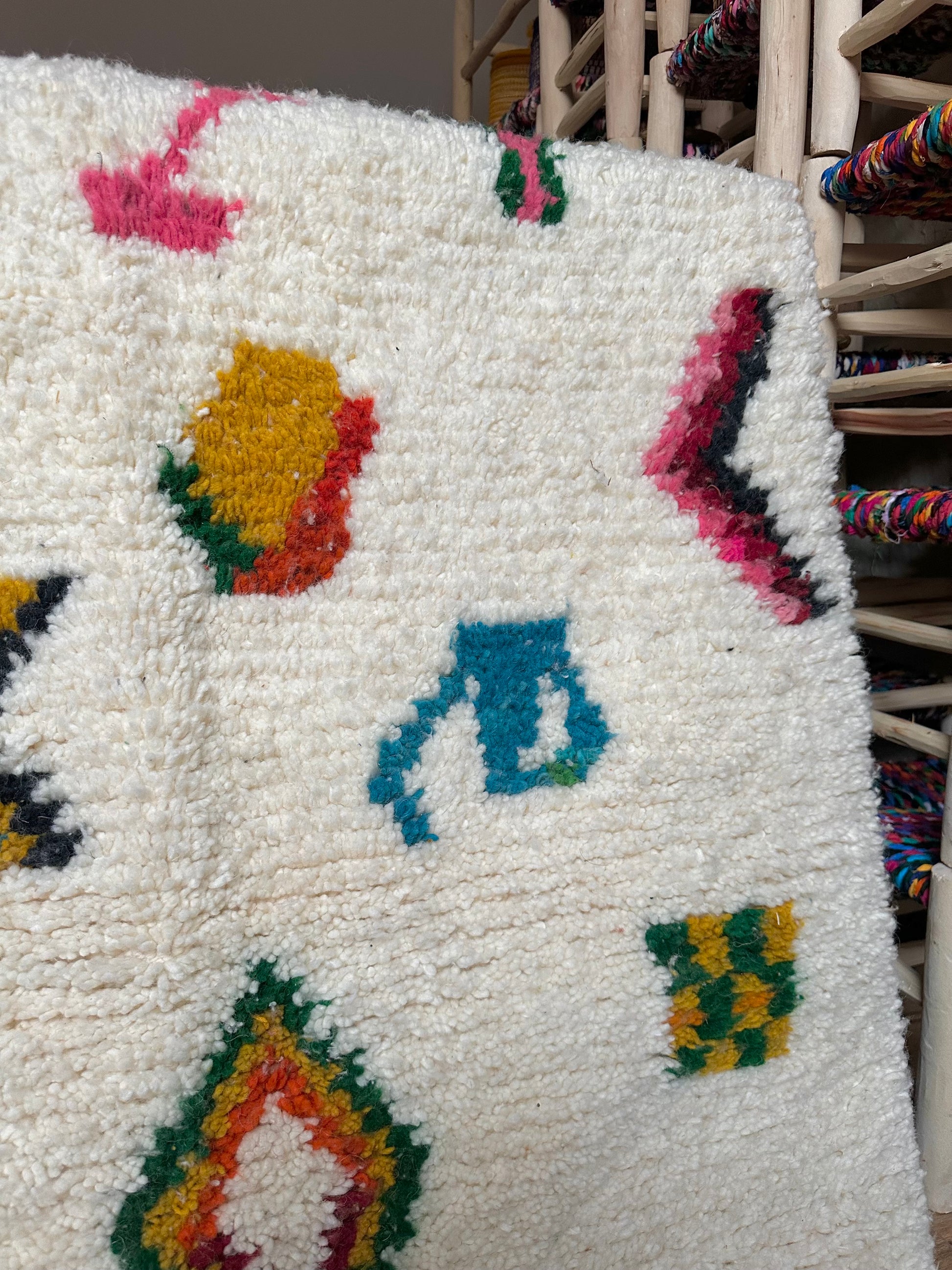 Détail des motifs colorés d’un tapis artisanal marocain en laine, réalisé à la main selon un savoir-faire traditionnel.