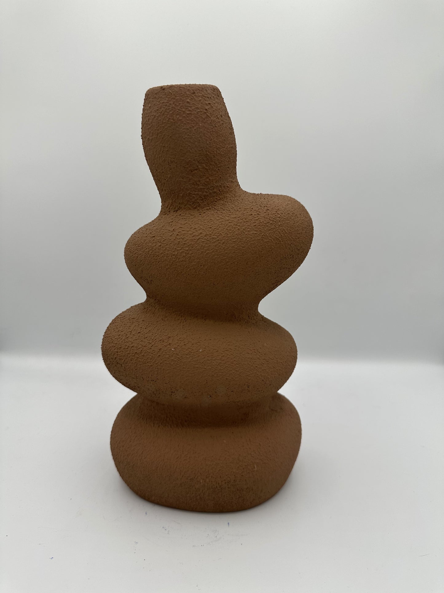 Vase ondulé en terre cuite de couleur marron, finition texturée mate, pour une décoration intérieure bohème et naturelle.