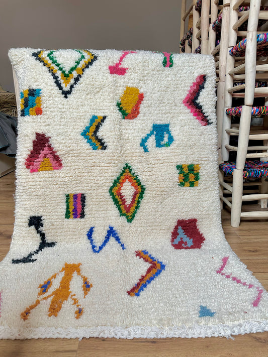 tapis artisanal marocain en laine, fait main au Maroc, pièce unique aux motifs colorés inspirés de l’art berbère.