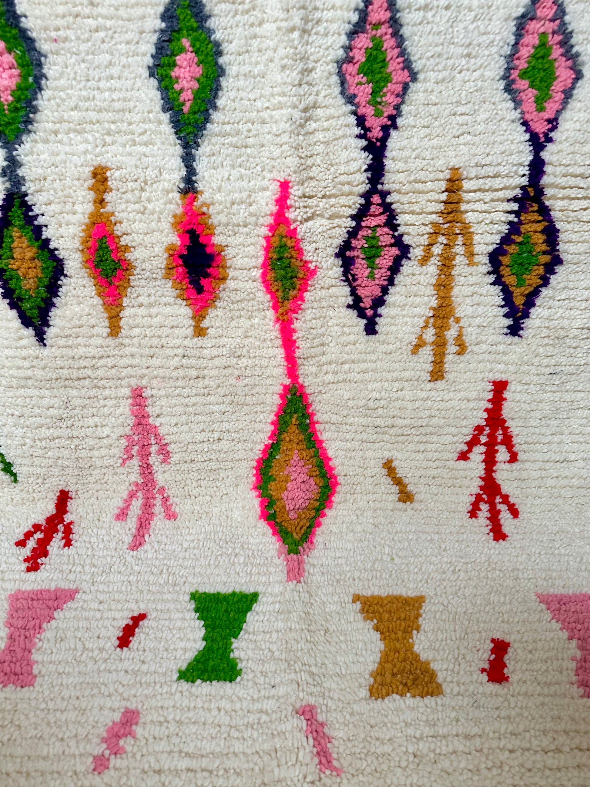 Détail des motifs colorés d’un tapis berbère marocain en laine, tissé à la main selon un savoir-faire artisanal traditionnel.