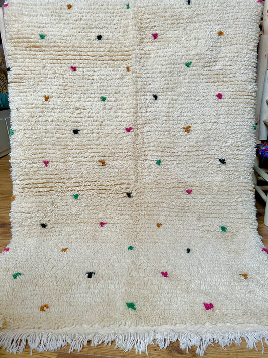 Tapis berbère marocain en laine 100 % naturelle, fait main au Maroc, pièce artisanale unique au style minimaliste avec touches colorées.