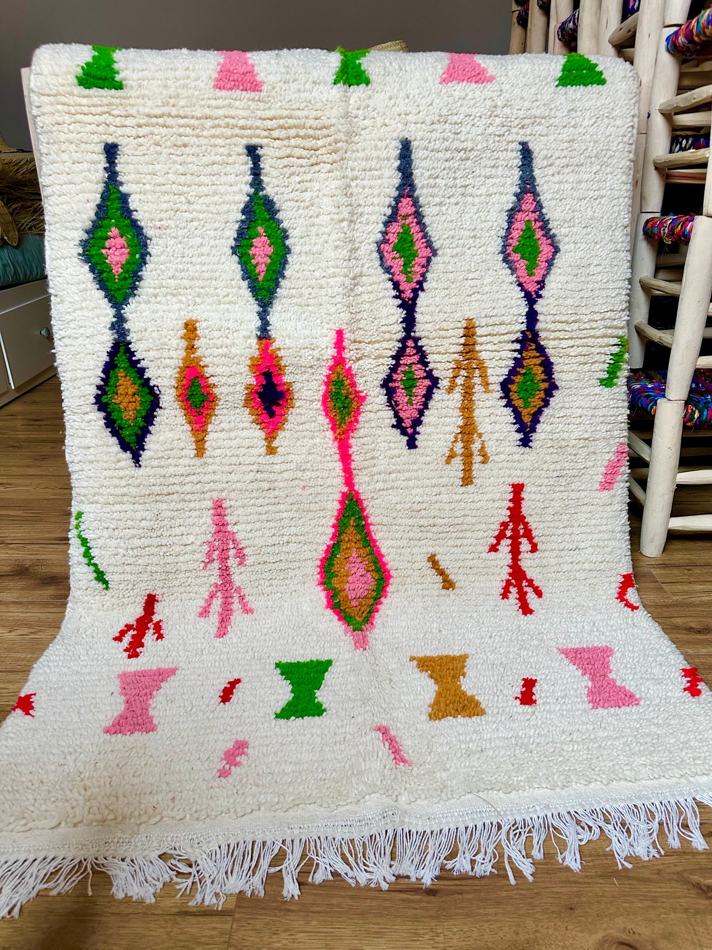 Tapis berbère marocain en laine 100 % naturelle, fait main au Maroc, pièce artisanale unique aux motifs colorés et franges traditionnelles.