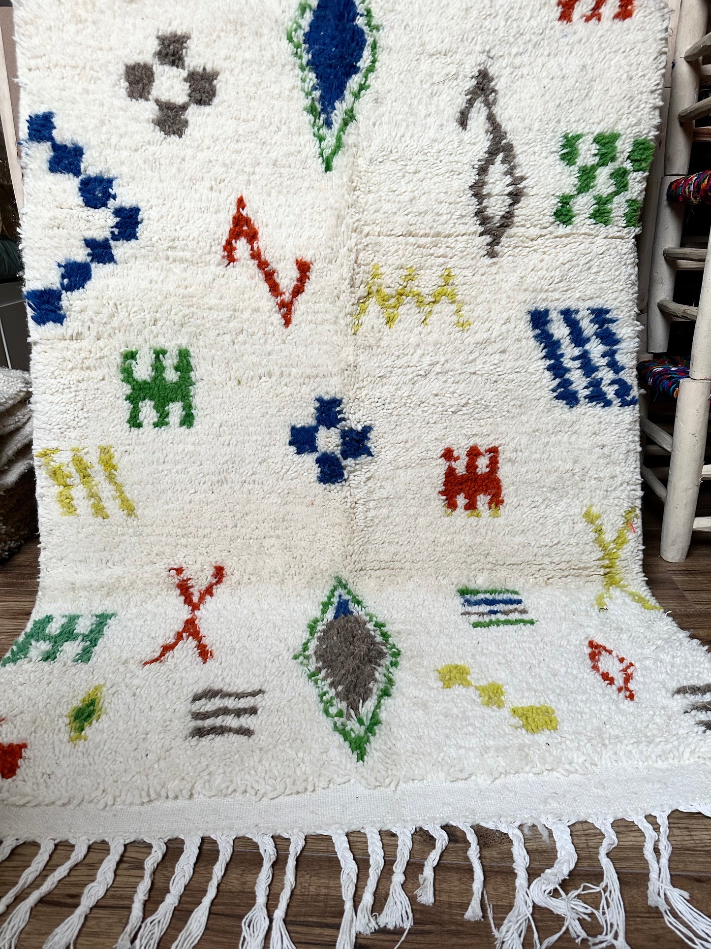 Tapis berbère marocain en laine 100 % naturelle, fait main au Maroc, pièce artisanale unique avec motifs géométriques et franges.